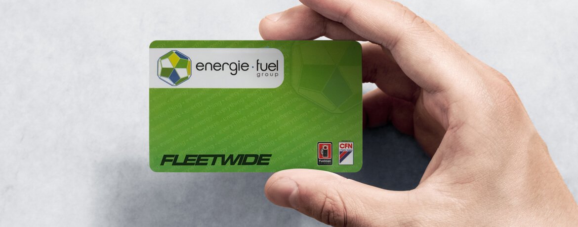 An image of a person holding the energie·fuel card with their right hand. There is a gray, textured background.