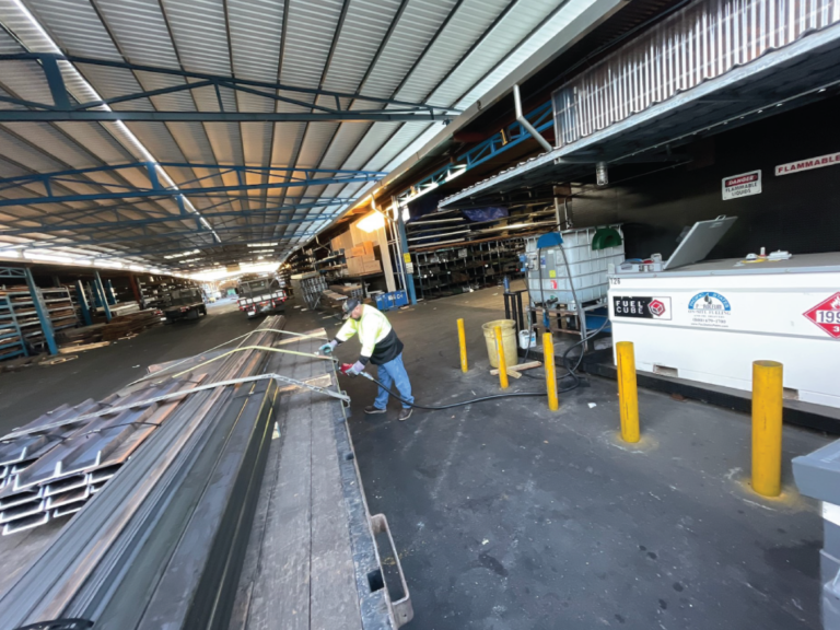 Picture of a worker fueling up a vehicle in a secured company yard using one of our bulk tanks.