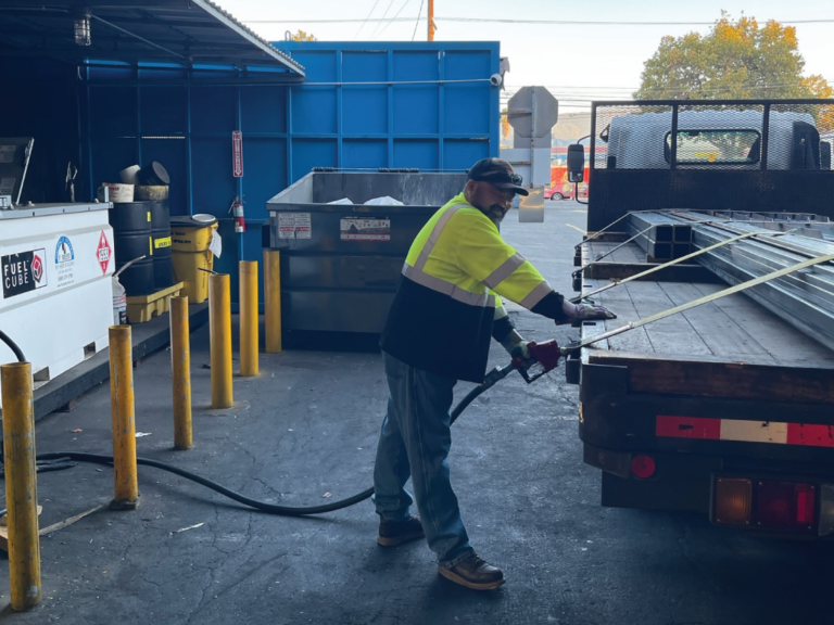 Man using mobile fueling tank to refuel vehicle at the company's maintenance site.
